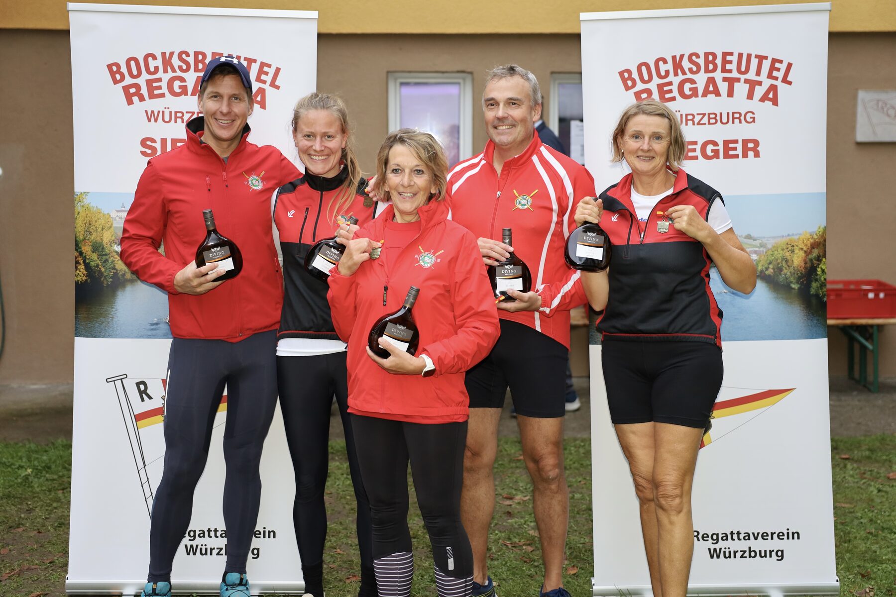 Siegermannschaft mit Bocksbeutel-Flaschen vor den Bannern der Bocksbeutelregatta